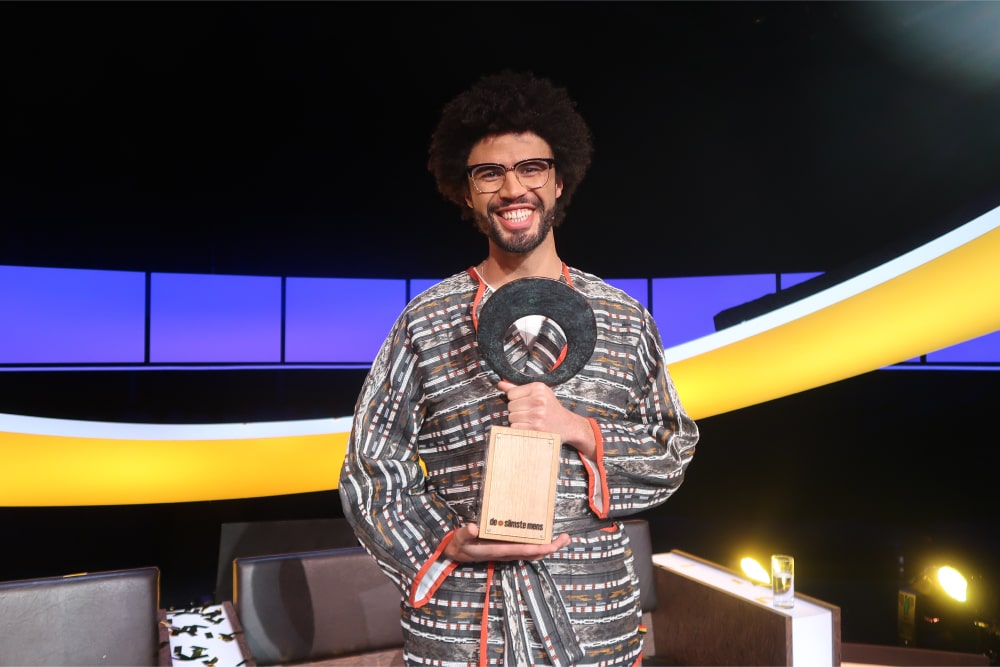 Marin Rombouts staat in de studio en houdt de trofee vast na het winnen van het 21ste seizoen van "de slimste mens"
